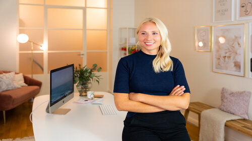 Caroline Preuss steht in einem gemütlich eingerichteten Büroraum