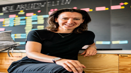 Claudia Feiner sitzt vor einer Tafel mit Postits; Text:'Moderne Arbeitswelten'