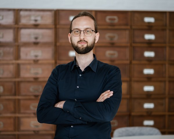 Foto von Dominik Schürmann, im Hintergrund Aktenschränke