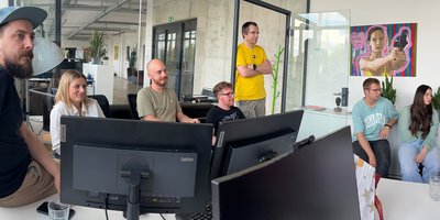 robotspaceship Team sitzt in einem Büro und lauscht einer Präsentation